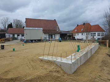 Luftaufnahme der Baustelle in Niederaichbach mit fertig gegossenem Fundament aus der Vogelperspektive.