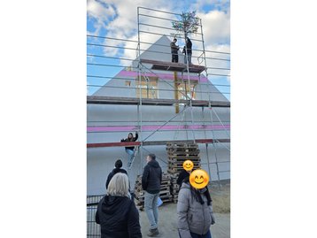Außenansicht beim Richtfest des Massivhaus-Rohbaus in Niederaichbach mit fertig aufgestelltem Dachstuhl.