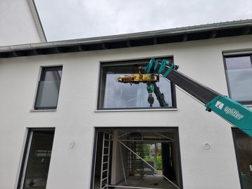 Die Montage der großen Fensterelemente des "Landhaus 142 Modern" in Zolling