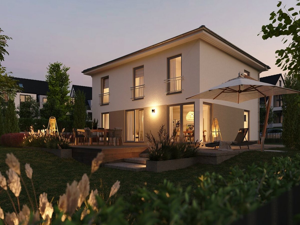 Modernes zweigeschossiges Einfamilienhaus in Massivbauweise bei Abenddämmerung. Große Fenster, stilvolle Außenbeleuchtung, Terrasse mit Sitzbereich und Sonnenschirm, gepflegter Garten mit Pflanzen und Rasen. Stimmungsvolle Darstellung eines hochwertigen Wohnhauses.