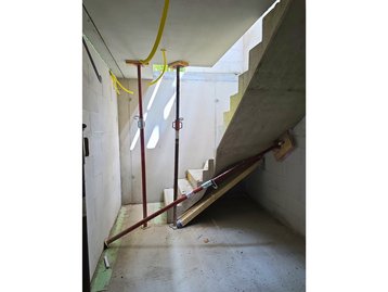 Montage und Abstützung der Betontreppe im Kellergeschoss während der Rohbauphase in Straßlach-Dingharting.