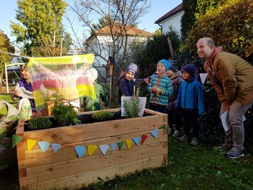 bepflanzte Hochbeete im Hintergrund Kinder