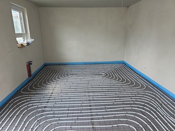 Fachgerecht verlegte Rohre der Fußbodenheizung auf der Dämmung vor dem Gießen des Estrichs.